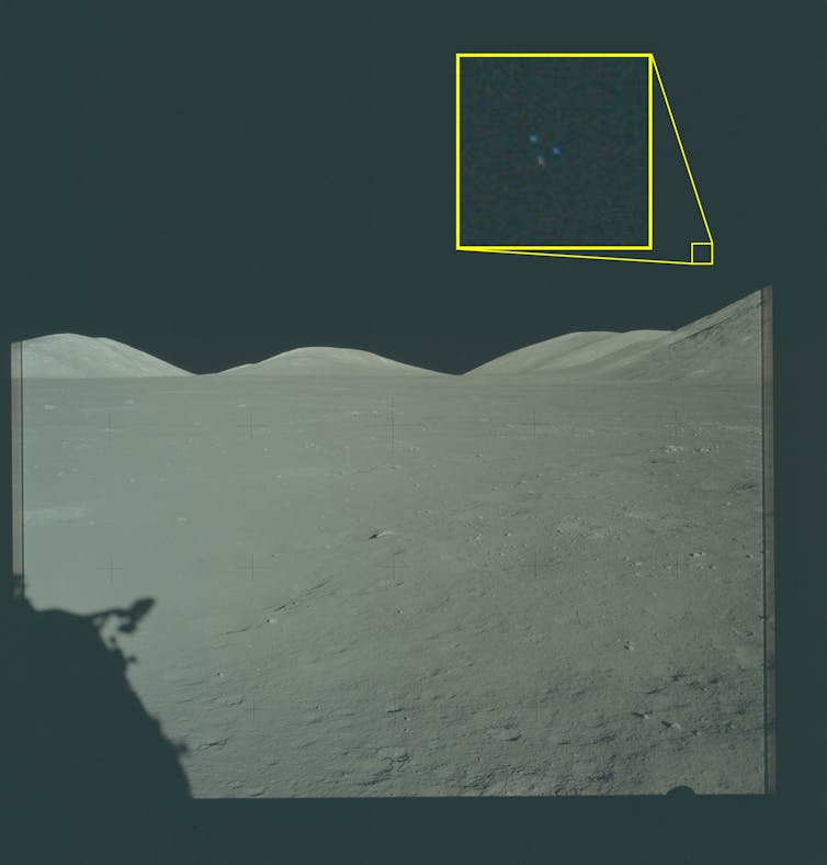 Una superficie lunar gris con tres puntos de colores visibles en el cielo.